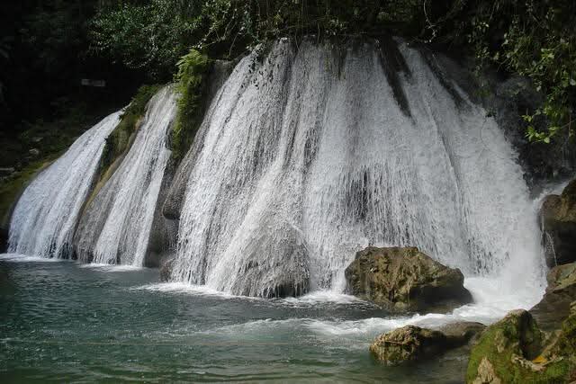 The cascading curtain of Reach Falls dropping into a clear emerald pool