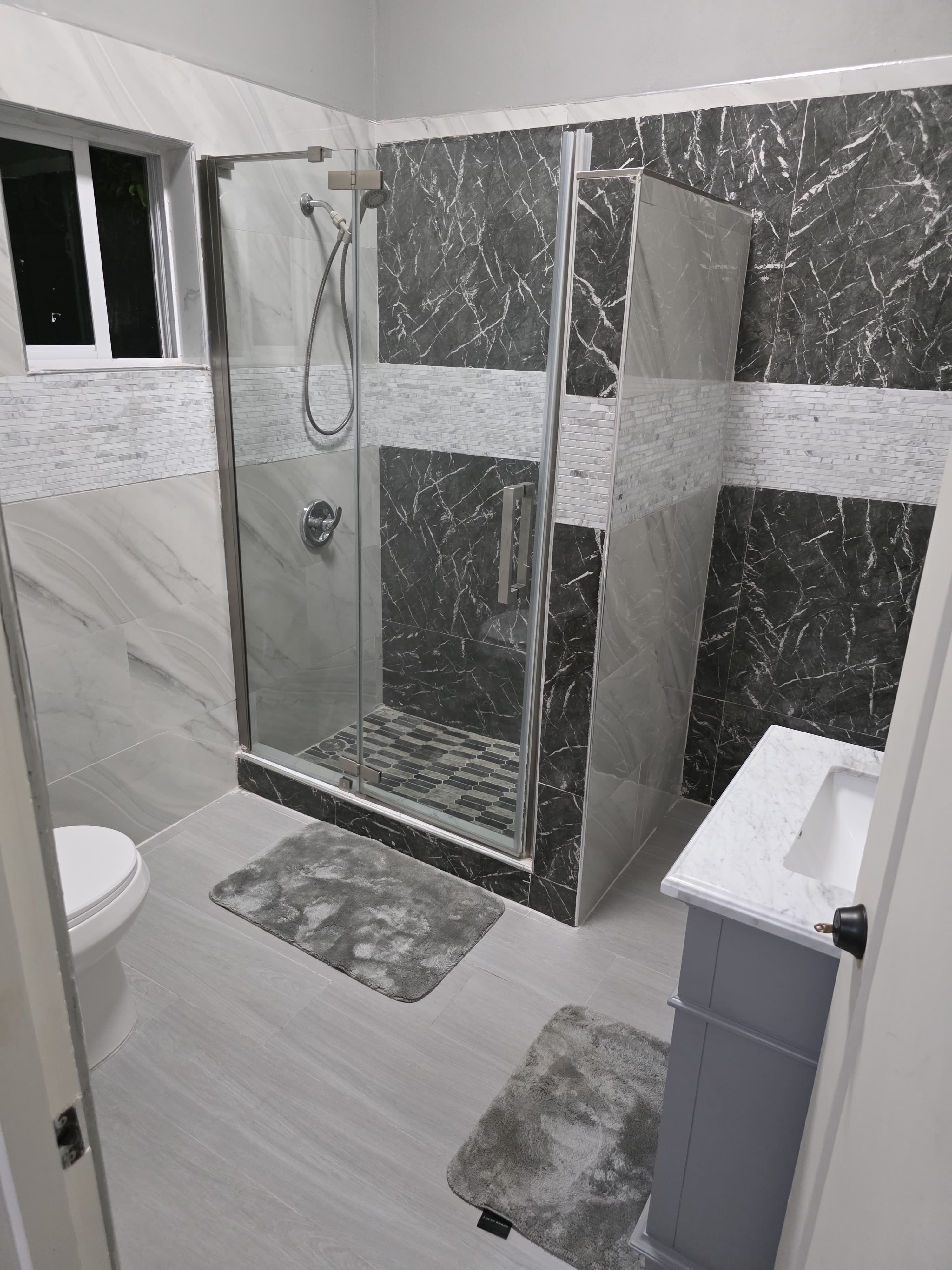 Modern bathroom with marble walls and walk-in shower