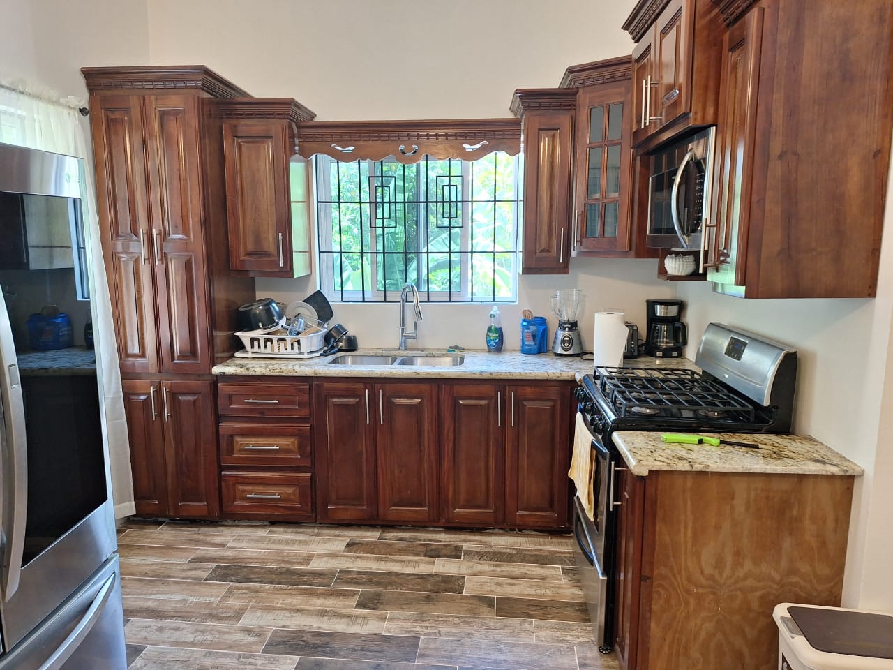 Full kitchen with rich wood cabinetry, granite counters and stainless appliances