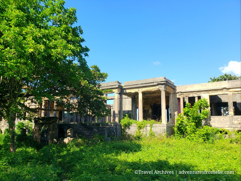 The roofless concrete columns and arches of Folly Great House overgrown with greenery (placeholder image — to be replaced)